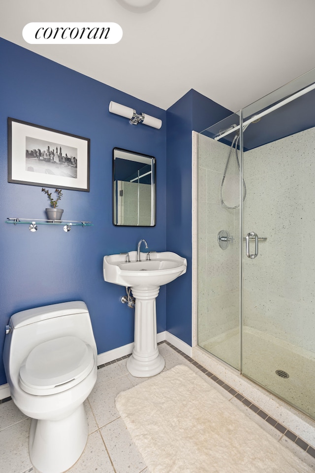 full bathroom with baseboards, a shower stall, toilet, and a sink