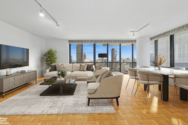 living area with track lighting, a city view, and expansive windows