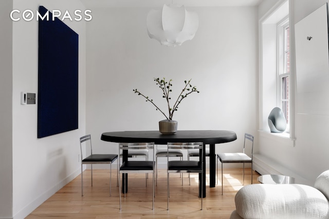 dining space with healthy amount of natural light, light wood finished floors, and baseboards