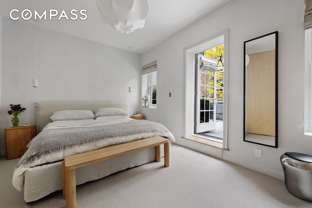 carpeted bedroom with access to exterior and baseboards