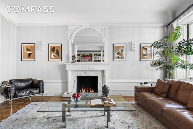 living area with a fireplace and ornamental molding