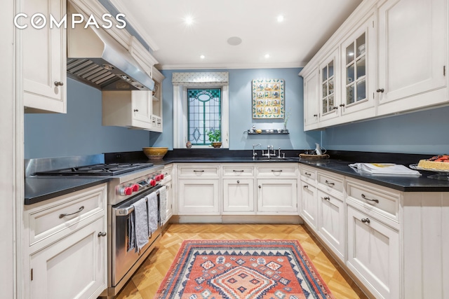 67 Riverside Dr Unit 1A, New York City, NY 10024 - kitchen featuring stainless steel range, wall chimney range hood, ornamental molding, white cabinetry, and dark countertops