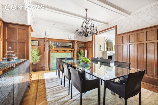 67 Riverside Dr Unit 1A, New York City, NY 10024 - dining area featuring wallpapered walls, a warm lit fireplace, a chandelier, a decorative wall, and a wainscoted wall