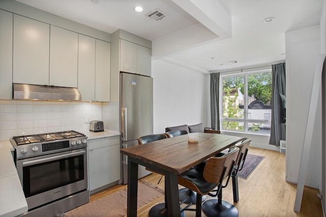 686 Mac Donough St Unit 3A, New York City, NY 11233 - kitchen with stainless steel appliances, under cabinet range hood, tasteful backsplash, light wood finished floors, and recessed lighting