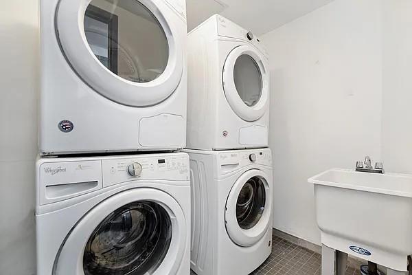 686 Mac Donough St Unit 3A, New York City, NY 11233 - laundry room featuring estacked washer and dryer, tile patterned flooring, and baseboards