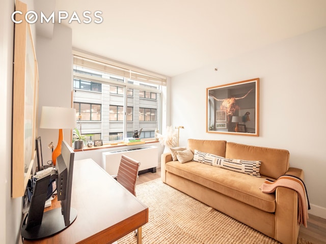 84 Front St Unit 5E, New York City, NY 11201 - living room featuring wood finished floors, a desk, and baseboards