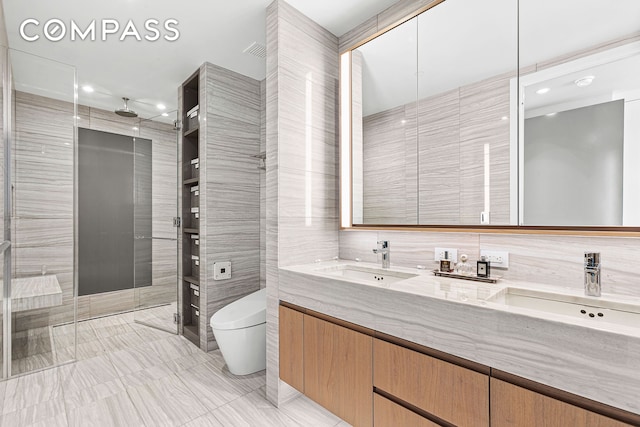 full bath with tile walls, toilet, tiled shower, double vanity, and recessed lighting