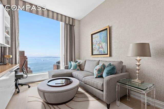 living room with wood finished floors, baseboards, and a water view