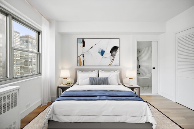 bedroom featuring radiator and wood finished floors