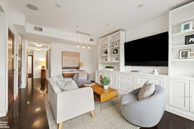 living area with dark wood-style flooring and recessed lighting