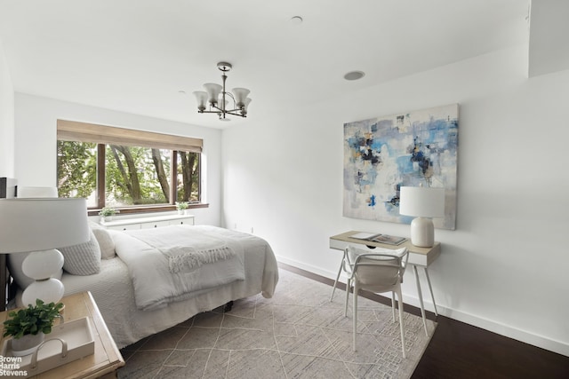 bedroom featuring a chandelier, baseboards, and wood finished floors