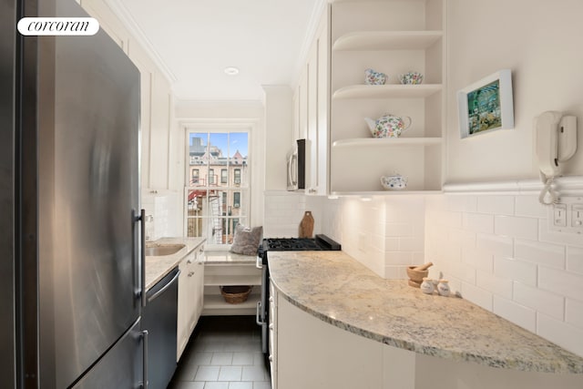 kitchen featuring appliances with stainless steel finishes, tasteful backsplash, white cabinetry, light stone countertops, and ornamental molding