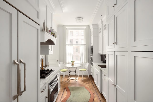 kitchen featuring stainless steel appliances, white cabinets, crown molding, and a sink