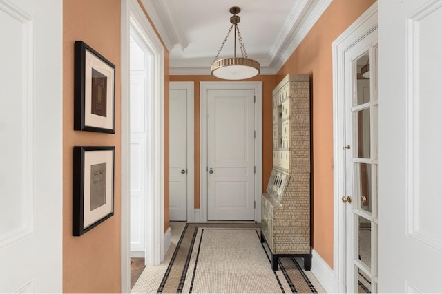 hallway featuring crown molding, inlaid floor details, and baseboards
