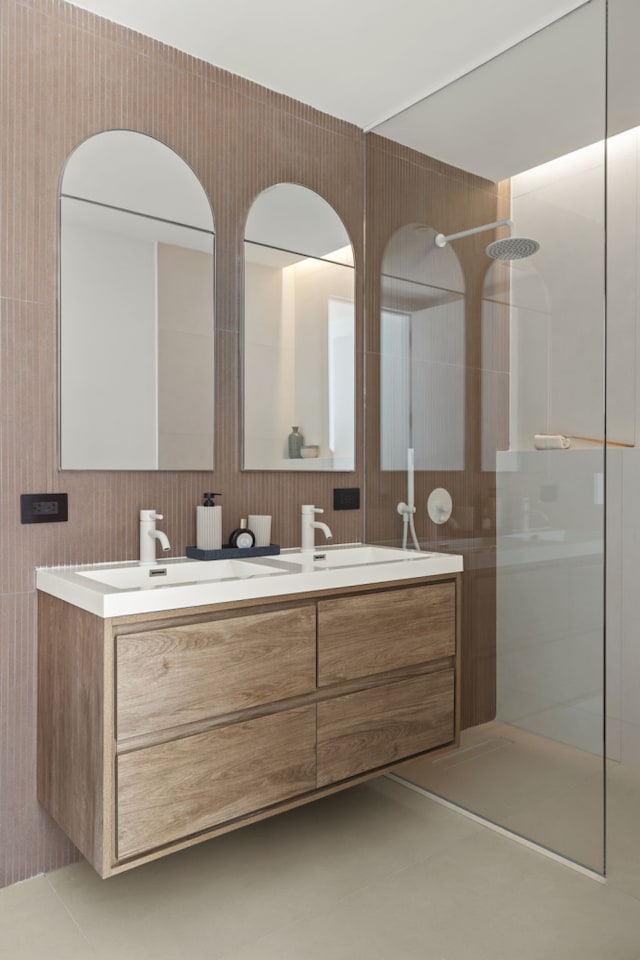 full bathroom with a walk in shower, double vanity, and tile patterned floors