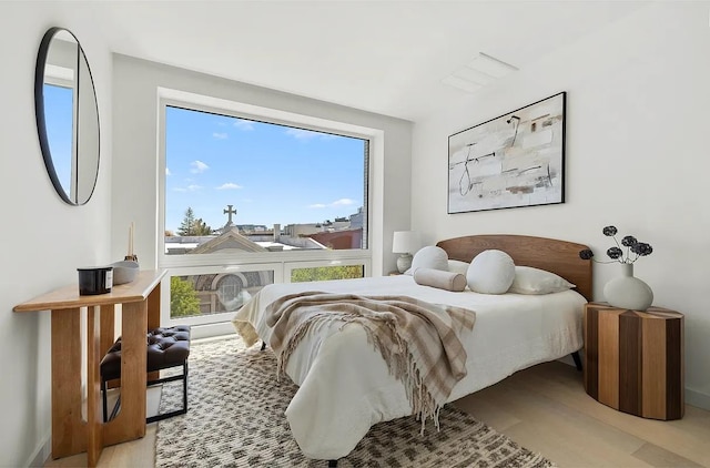 bedroom featuring multiple windows and light wood-style floors