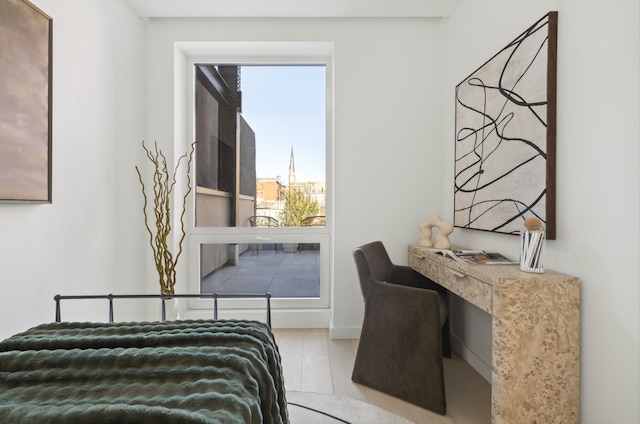 bedroom featuring an office area and baseboards