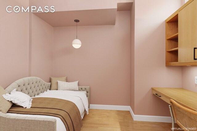 bedroom with light wood-style floors and baseboards