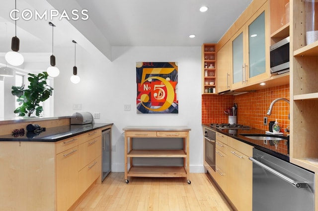 kitchen featuring appliances with stainless steel finishes, a sink, dark countertops, tasteful backsplash, and recessed lighting