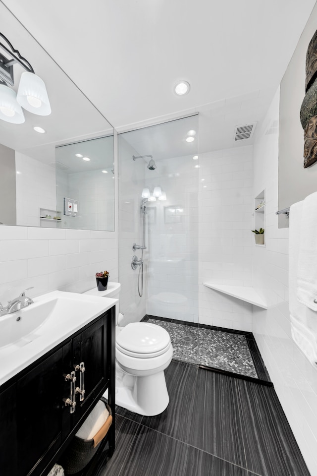9201 Shore Rd Unit C201, New York City, NY 11209 - bathroom featuring toilet, tile walls, walk in shower, vanity, and tile patterned flooring