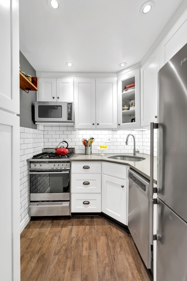 9201 Shore Rd Unit C201, New York City, NY 11209 - kitchen featuring stainless steel appliances, a sink, white cabinets, glass insert cabinets, and tasteful backsplash