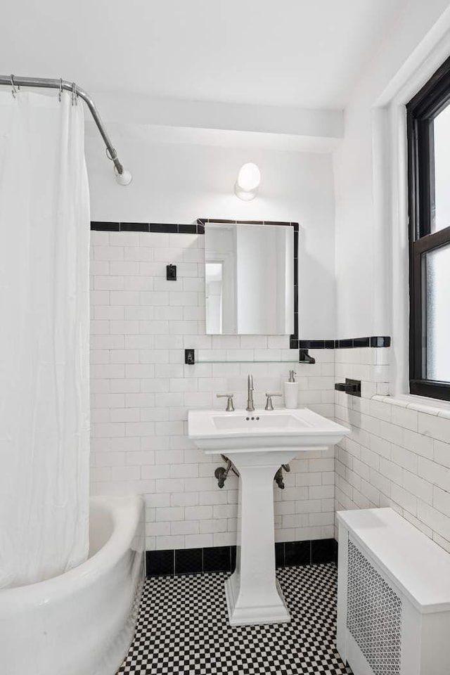 205 E 78th St Unit 5S, New York City, NY 10075 - bathroom featuring radiator heating unit, tile walls, plenty of natural light, shower / bath combo, and a wainscoted wall