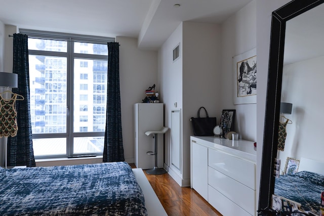 bedroom featuring multiple windows and dark wood-style floors
