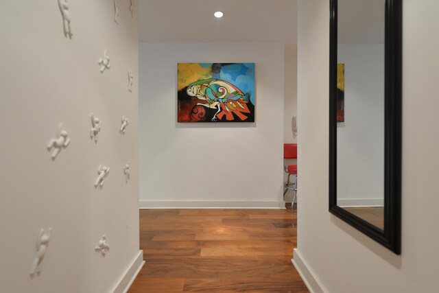 hallway with baseboards, wood finished floors, and recessed lighting