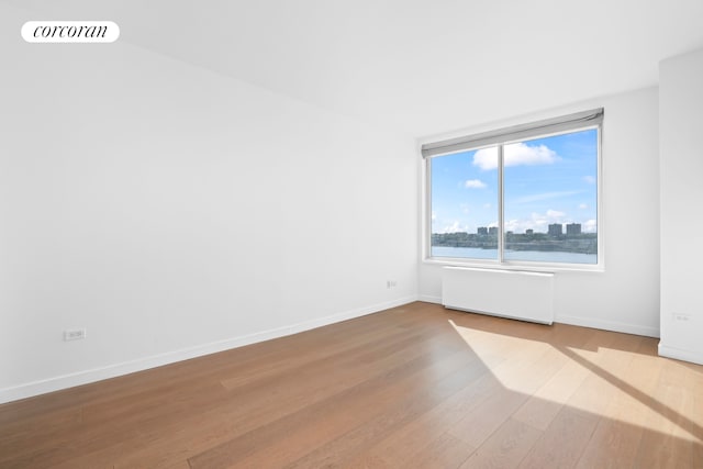 200 Riverside Blvd Unit 19J, New York City, NY 10069 - unfurnished room with radiator, wood finished floors, baseboards, and a city view