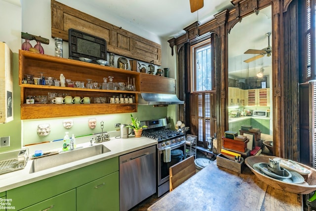kitchen featuring stainless steel appliances, green cabinetry, a ceiling fan, under cabinet range hood, and light countertops