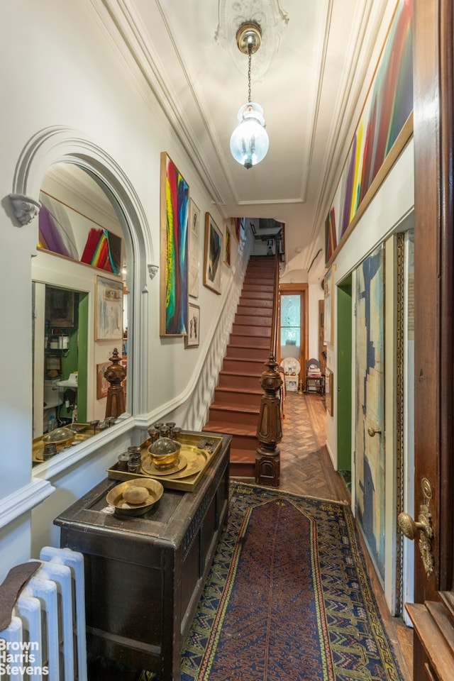 hallway featuring stairway, radiator, and crown molding