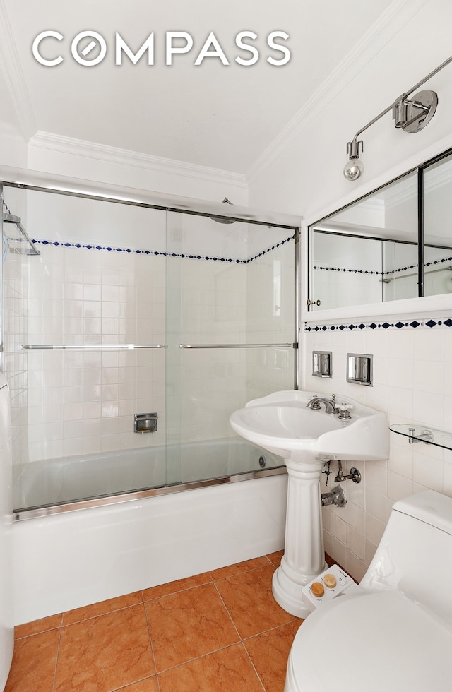 bathroom with crown molding, toilet, enclosed tub / shower combo, tile patterned flooring, and a sink