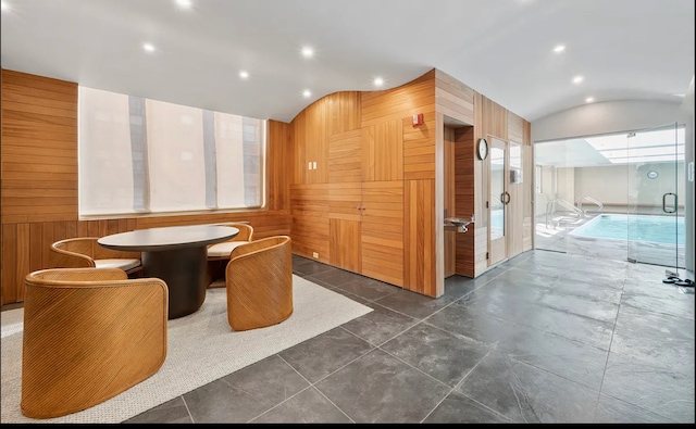 350 E 82nd St Unit 7-G, New York City, NY 10028 - dining room featuring recessed lighting, lofted ceiling, and wooden walls