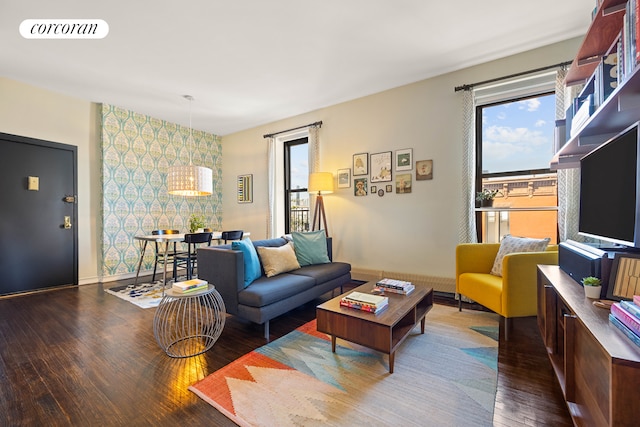 living area featuring wood finished floors, baseboards, and an accent wall