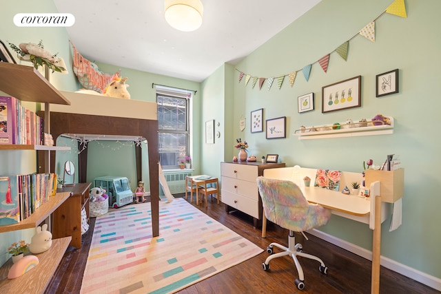 bedroom featuring wood finished floors, baseboards, and radiator heating unit