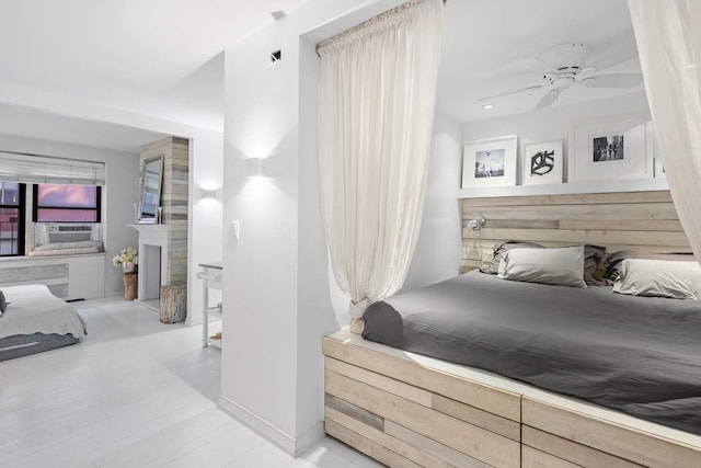 bedroom with a fireplace, ceiling fan, and cooling unit