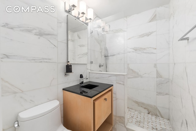 bathroom with tile walls, a marble finish shower, toilet, and vanity