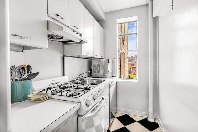 kitchen with white range with gas stovetop, under cabinet range hood, a sink, light countertops, and white cabinets