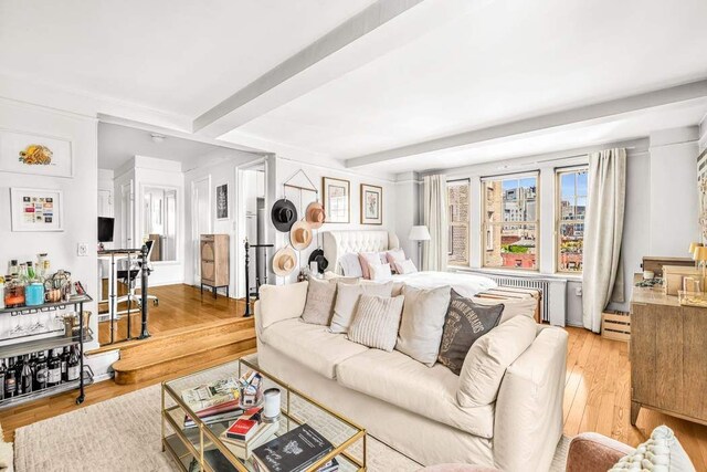 299 W 12th St Unit 7Gh, New York City, NY 10014 - living area with beam ceiling, light wood-style floors, radiator heating unit, and a baseboard heating unit