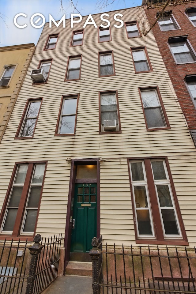 152 N 9th St Unit 1R, New York City, NY 11249 - view of building exterior featuring a fenced front yard and cooling unit