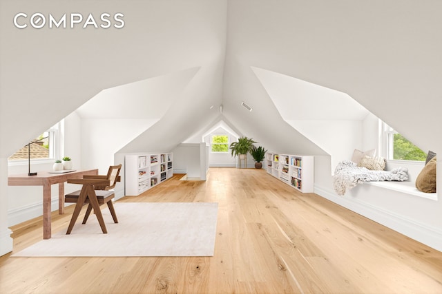 additional living space with wood finished floors, vaulted ceiling, and baseboards