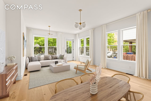 sunroom featuring healthy amount of natural light and a chandelier