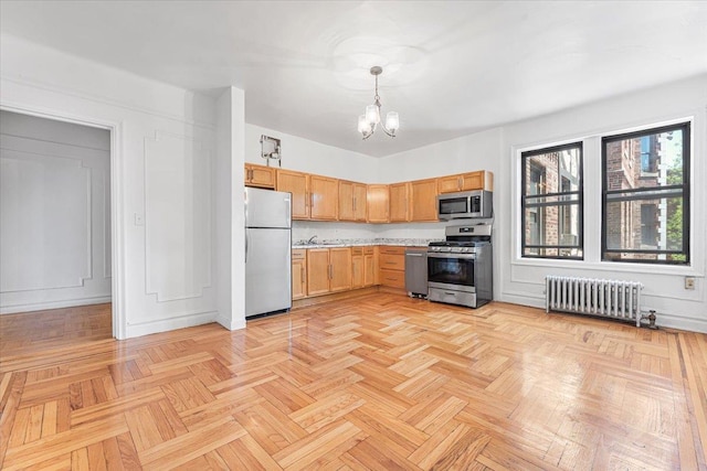 kitchen featuring stainless steel appliances, radiator, light countertops, a chandelier, and hanging light fixtures