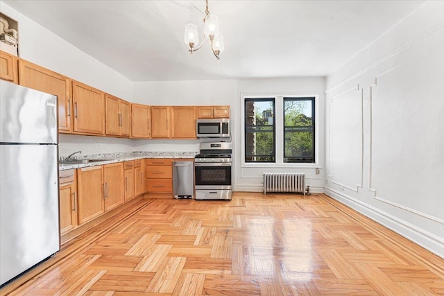 kitchen featuring appliances with stainless steel finishes, radiator, a sink, a chandelier, and pendant lighting