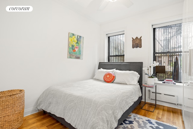 322 6th St Unit 5, New York City, NY 11215 - bedroom featuring baseboard heating, ornamental molding, wood finished floors, baseboards, and a ceiling fan