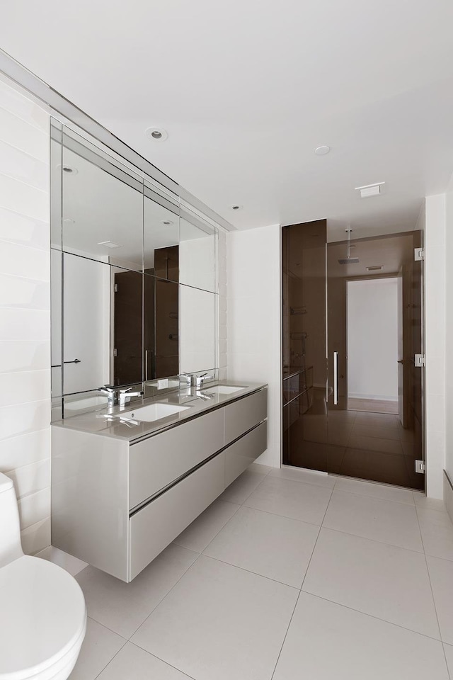 bathroom featuring double vanity, tile patterned floors, and toilet