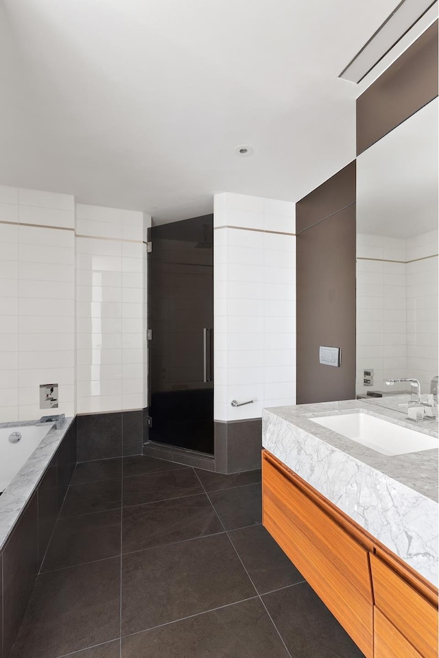 bathroom featuring tile patterned flooring, vanity, and a garden tub