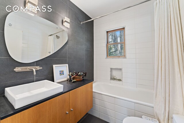 227 W 260th St, New York City, NY 10471 - full bathroom with a sink, tiled shower / bath, toilet, and tile walls