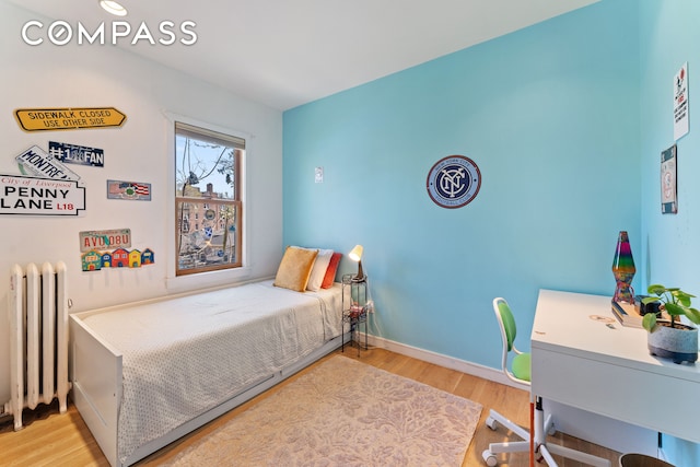 227 W 260th St, New York City, NY 10471 - bedroom featuring radiator heating unit, wood finished floors, baseboards, and an office area