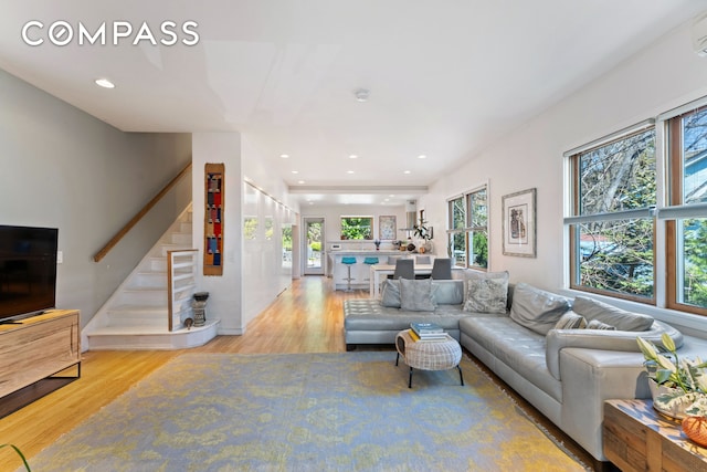 227 W 260th St, New York City, NY 10471 - living area featuring stairs, wood finished floors, healthy amount of natural light, a wall mounted air conditioner, and recessed lighting